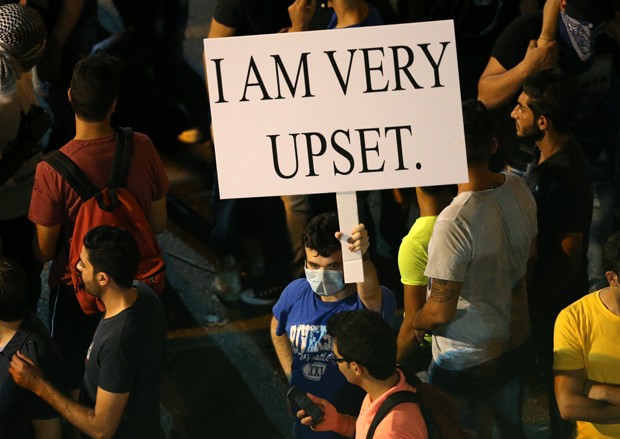 Manifestante leva cartaz para protestar contra a crise do lixo em Beirute, no Líbano, no sábado (29)  (Foto: Hussein Malla /AP )