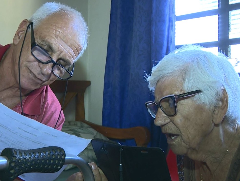 Wagner (filho) e Rosalina Rodrigues conferem documentos para tentar, mais uma vez, comprovar que a aposentada não morreu — Foto: Vanderlei Duarte/EPTV