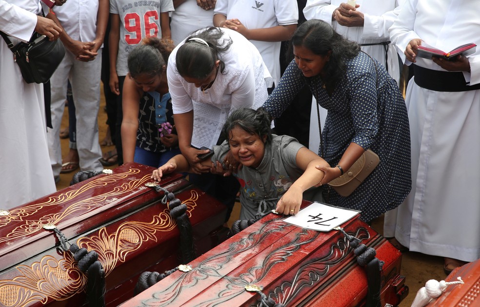 Mulher chora durante enterro coletivo nesta terça-feira (23) em cemitério perto da igreja de Saint Sebastian, em Negombo, na Sri Lanka  — Foto: Athit Perawongmetha/ Reuters