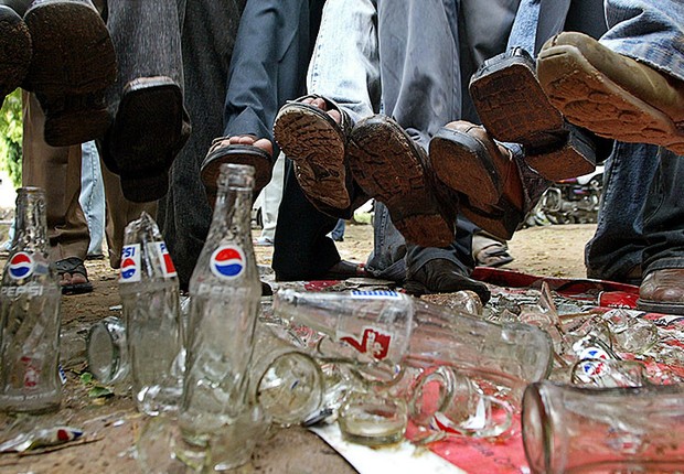 Manifestantes pisam sobre garrafas de Pepsi-Cola e Coca-Cola durante protesto pela proibição de refrigerantes na Índia (Foto: Amit Dave/Reuters)