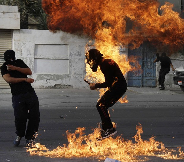 manifestante segurada bomba caseira feita com gasolina (Foto: Hasan Jamali/AP)