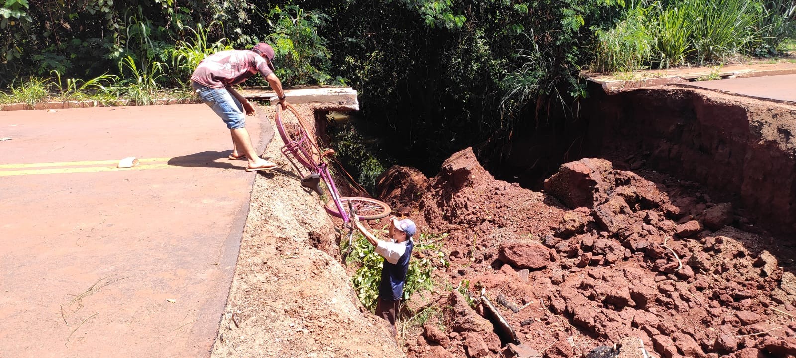 Moradores são flagrados cruzando a pé cratera de 10 metros que se abriu em rua de MS; veja vídeo
