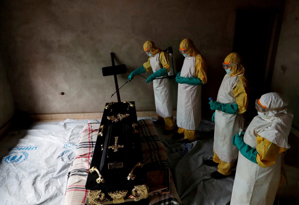 FuncionÃ¡rios de saÃºde pulverizam uma sala durante o funeral de Kavugho Cindi Dorcas, suspeito de morrer de Ebola em Beni, na provÃ­ncia de Kivu do Norte, na RepÃºblica DemocrÃ¡tica do Congo â€” Foto: Goran Tomasevic/Reuters
