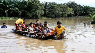 Pessoas afetadas por inundações causadas pela tempestade tropical Julia são evacuadas de barco, no município de Choloma, departamento de Cortes, Honduras  — Foto: WENDELL ESCOTO/AFP