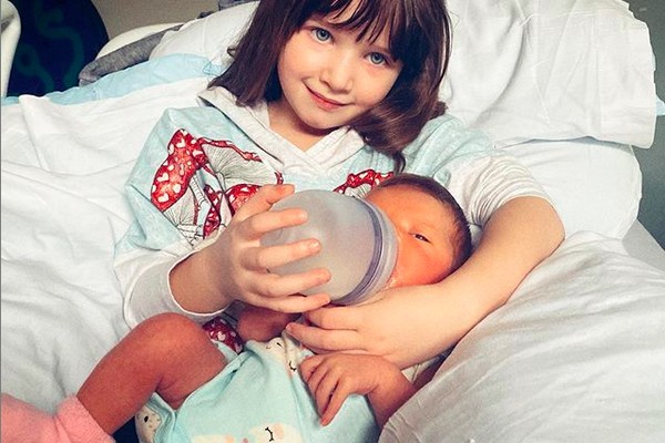 A filha de 4 anos da atriz Milla Jovovich amamentando a filha recém-nascida da celebridade (Foto: Instagram)