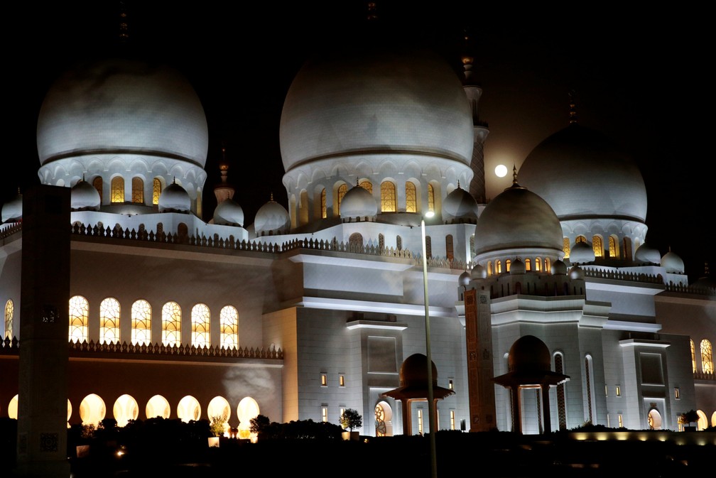 ONDE ESTÁ A LUA? A foto de Christopher Pik, da Reuters, mostra o "nascer" da Lua de Sangue perto da Grande Mesquita Sheikh Zayed. Ao contrário das imagens com grandes teleobjetivas, o satélite aparece em tamanho bem mais discreto. (Foto: Christopher Pik/Reuters)