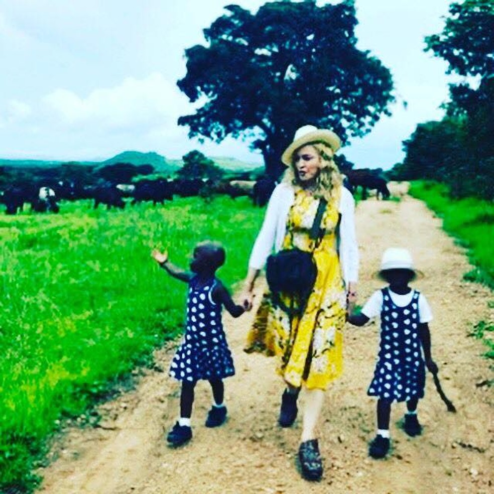 Madonna caminha as filhas gªmeas que adotou no Malawi Foto Reprodu§£o