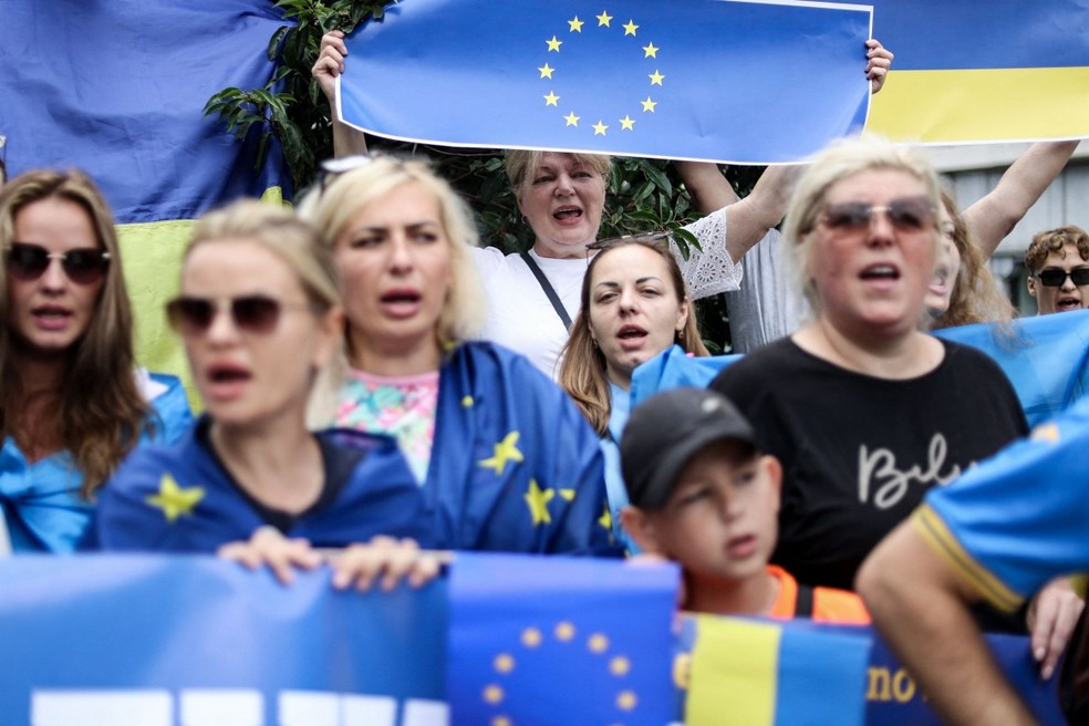 Manifestantes se reúnem do lado de fora da sede da UE em apoio à adesão da Ucrânia nesta quinta-feira — Foto: Kenzo TRIBOUILLARD / AFP