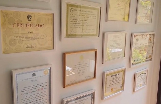 Numa parede estão diplomas e certificados de Bela (Foto: Reprodução/ YouTube)