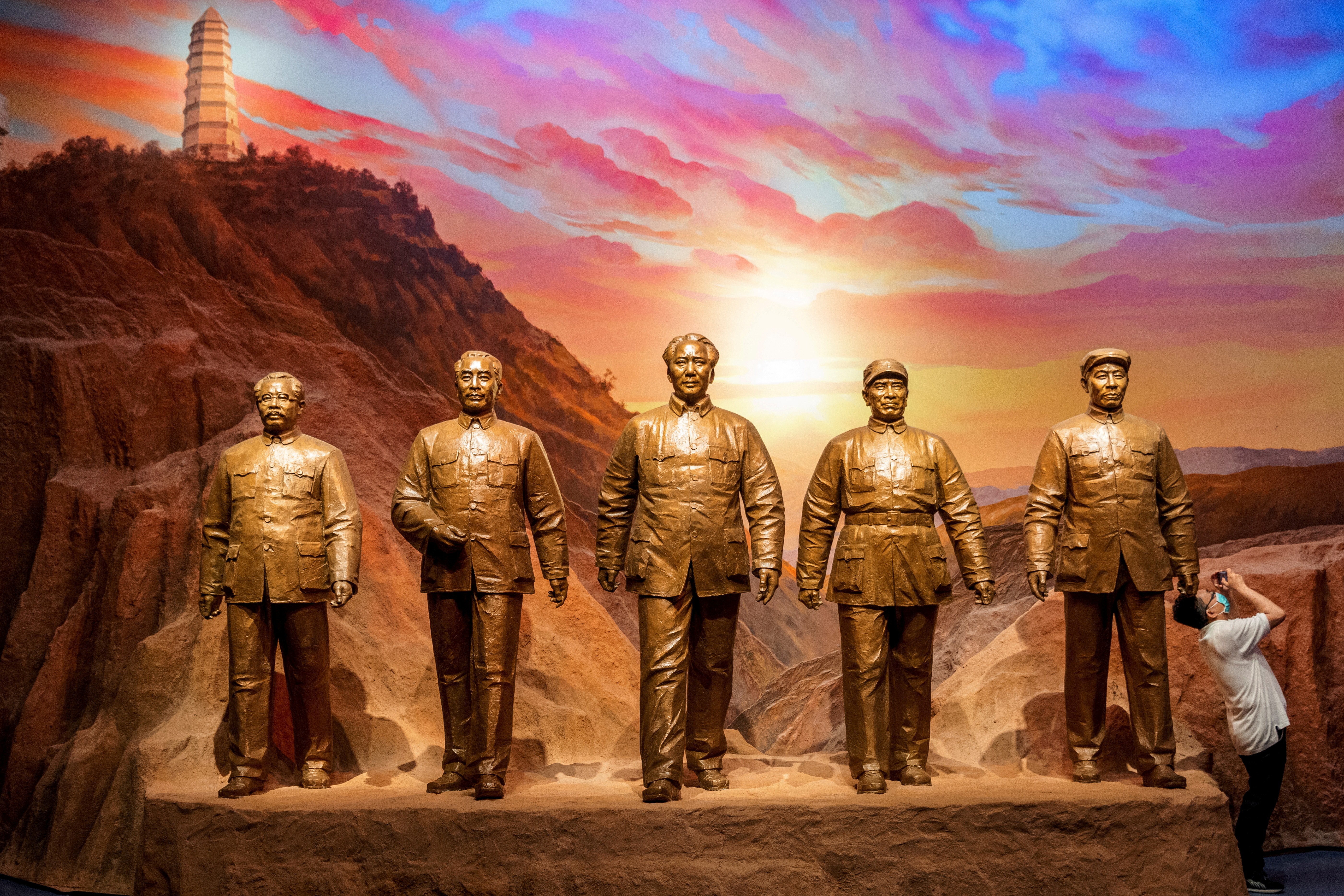 Um homem tira fotos ao lado de estátuas de antigos líderes comunistas chineses no Museu do Partido Comunista da China