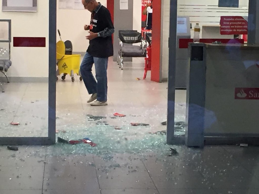 Criminosos destruÃ­ram a porta de vidro de uma agÃªncia bancÃ¡ria durante um assalto no Centro de Caruaru nesta sexta-feira (16) â€” Foto: Mavian Barbosa/G1