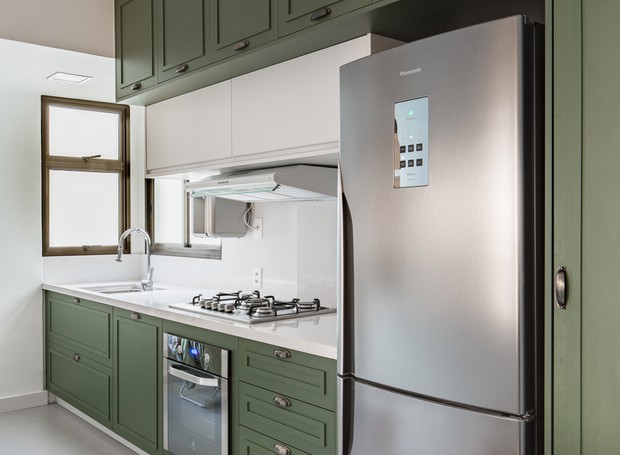 Os armários em mdf da cozinha foram pintados de verde para contrastar com os tons mais neutros da sala de jantar e da sala de estar (Foto: Joana França)