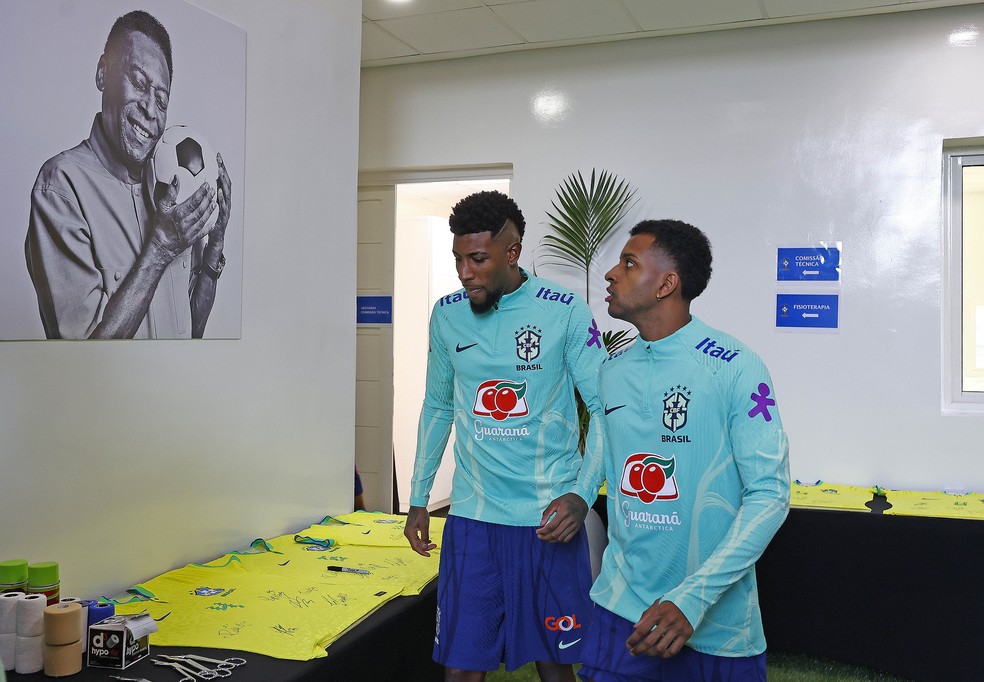 Emerson Royal e Rodrygo passam por imagem de Pelé em local de treinos da Seleção — Foto: Rafael Ribeiro / CBF