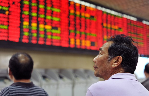 Investidores observam o painel eletrônico na Bolsa de Valores de Xangai (Foto: ChinaFotoPress/Getty Images)