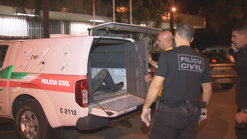 Preso por atirar em desavença é colocado dentro de carro da Polícia Civil (Foto: TV Globo/Reprodução)