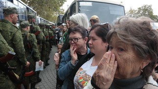 Familiares assistem à partida de seus entes para bases militares onde receberão treinamento antes de entrar em combate na Ucrânia. — Foto: AFP