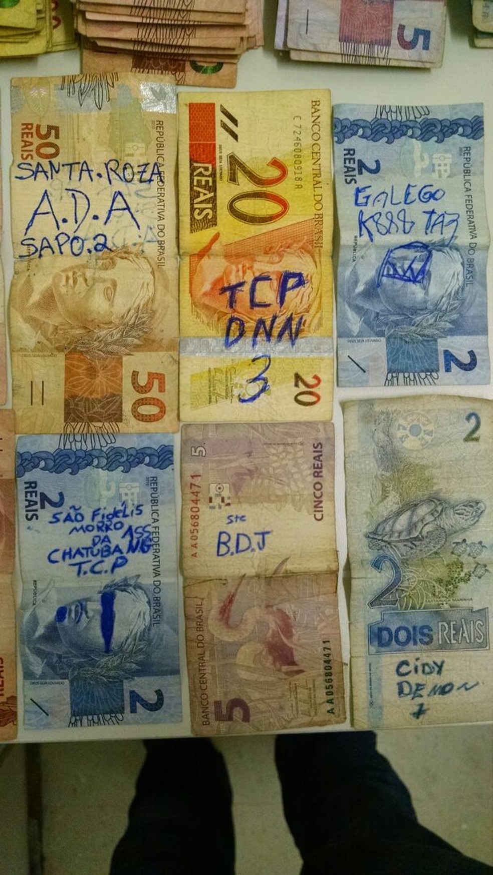 Dinheiro apreendido com detentos das duas facções sob a guarda de um agente penitenciário (Foto: Divulgação)