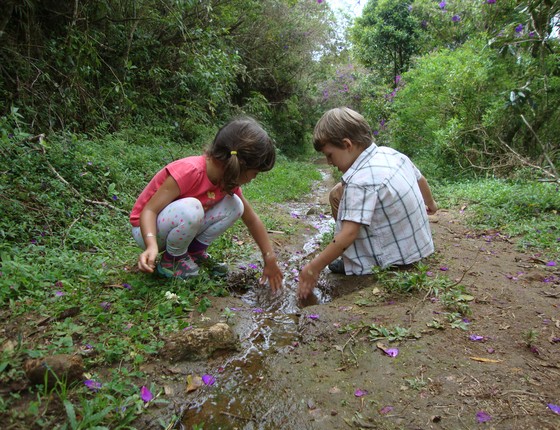 Crianças brincam com água numa área natural. Elas estão aprendendo sobre o ciclo da água, hidrologia, dinâmica de fluidos e muito mais (Foto: Lais Fleury - Divulgação Instituto Alana)