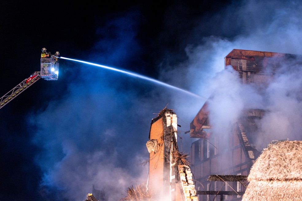 Bombeiros tentam conter incêndio em um prédio que abriga refugiados ucranianos em Gross Stroemkendorf, leste da Alemanha, na noite de 20 de outubro de 2022 — Foto:  Jens Büttner / DPA / AFP