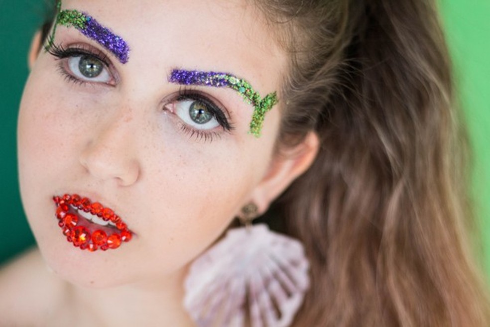 mulher usando sobrancelhas com glitter 