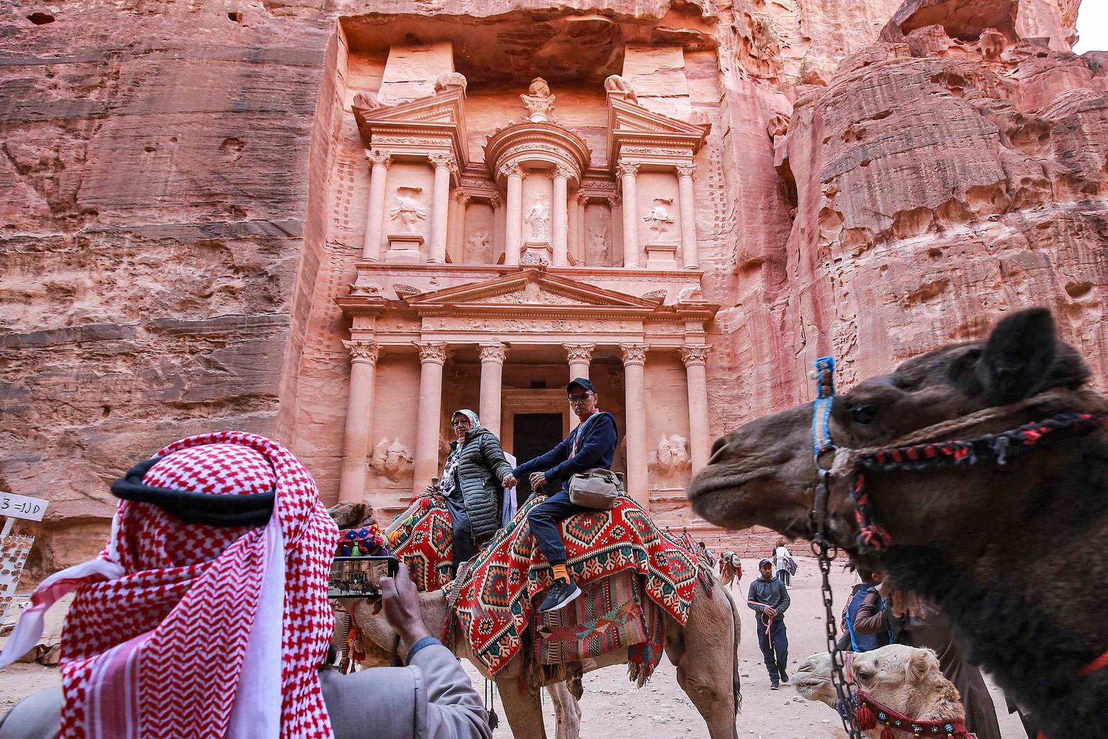Turista posa em frente à construção conhecida como Al Khazneh ('O Tesouro') em Petra, na Jordânia — Foto: Khalil Mazraawi / AFP