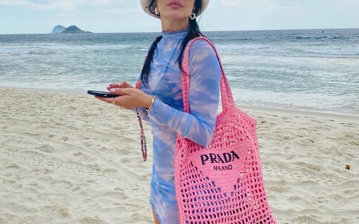 Isis Valverde vai à praia com bolsa grifada de R$ 9 mil