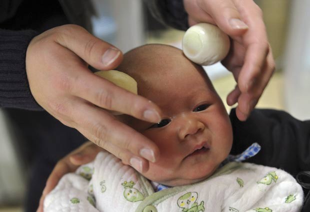 Bebê chinês ganhou uma massagem na cabeça com ovos após ter o cabelo cortado. (Foto: Reuters)
