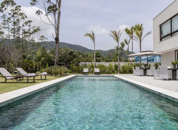 PISCINA | Integrada à natureza, a piscina é revestida de pedra hijau da Lantai. O paisagismo da SP Garden valoriza a arquitetura da casa projetada pela arquiteta Patricia Penna (Foto: Leandro Moraes / Divulgação)
