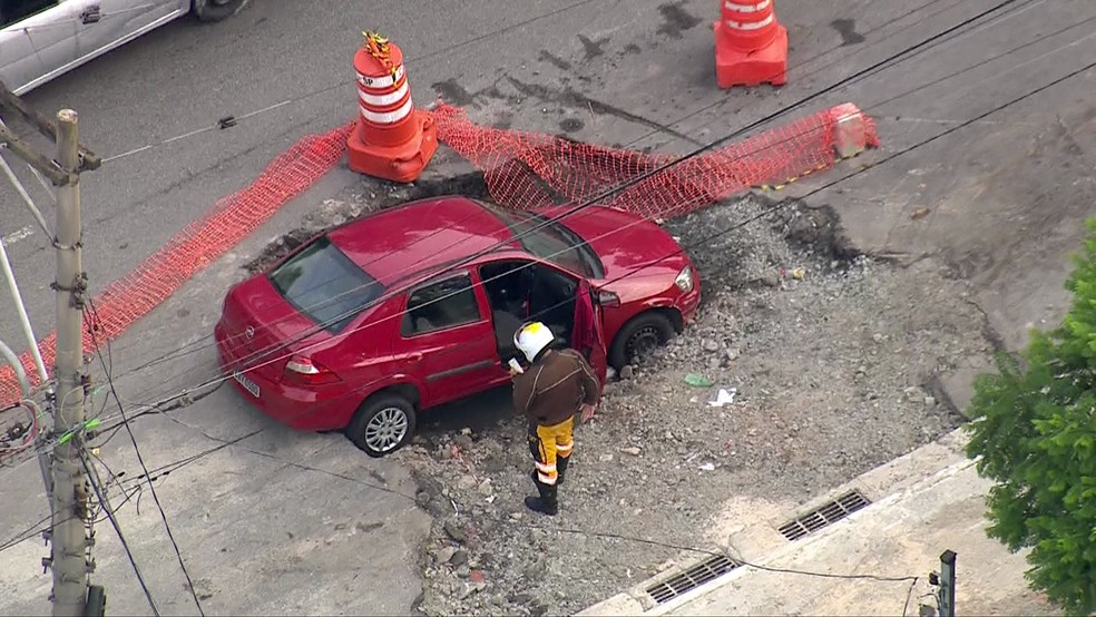 Carro cai em buraco na Zona Leste de SP — Foto: Reprodução/TV Globo