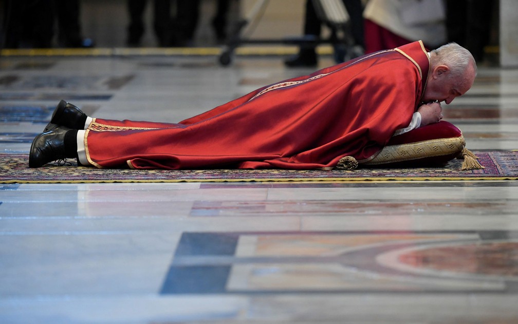 Papa Francisco se deita no chão da basílica de São Pedro, no Vaticano, em sinal de humilde obediência durante missa da Sexta-Feira Santa, no dia 10 de abril — Foto: Vatican Media/­Handout via Reuters