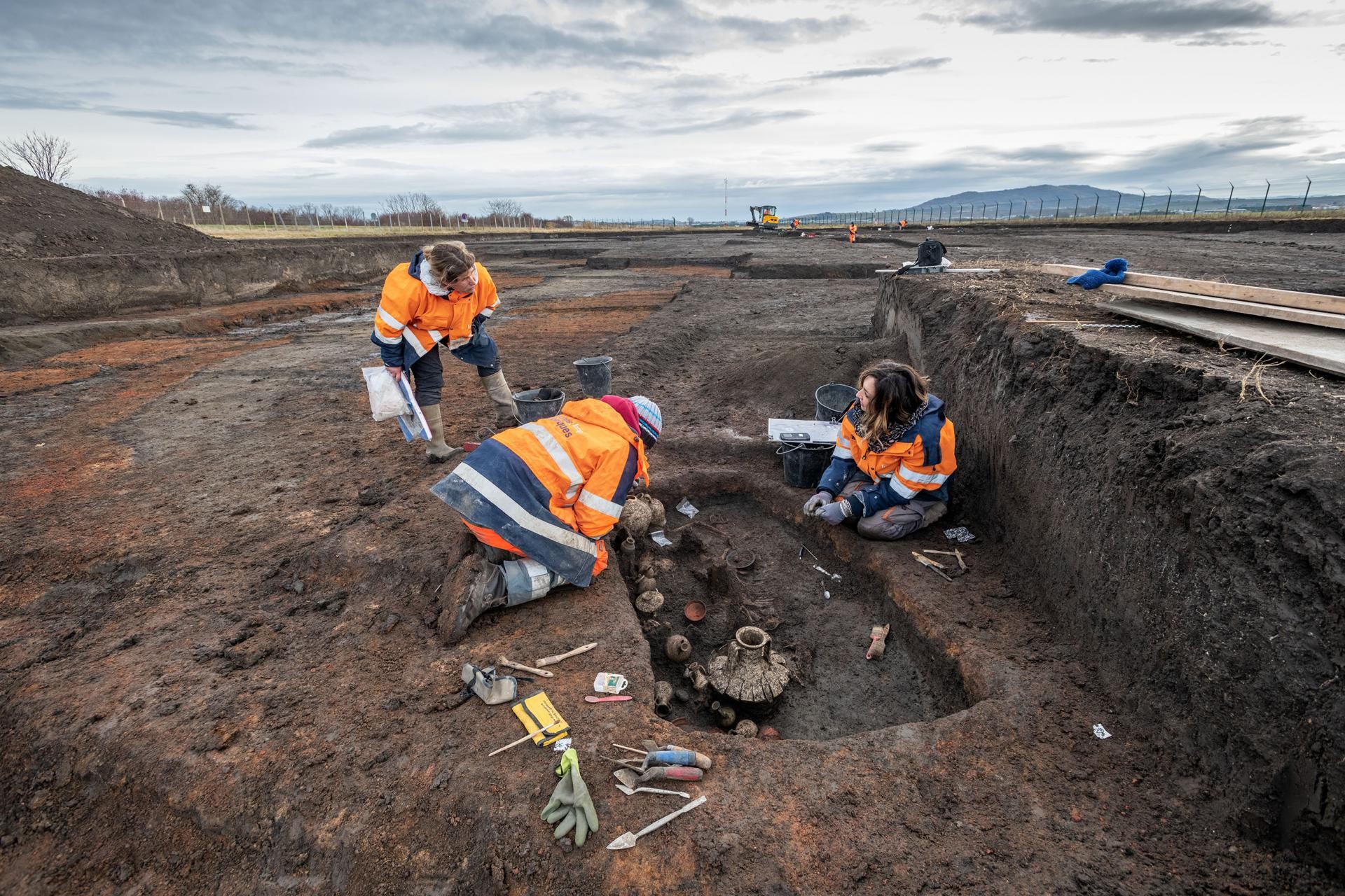 Arqueólogos escavam a cova ao lado das pistas do aeroporto (Foto: Denis Gliksman/Inrap)
