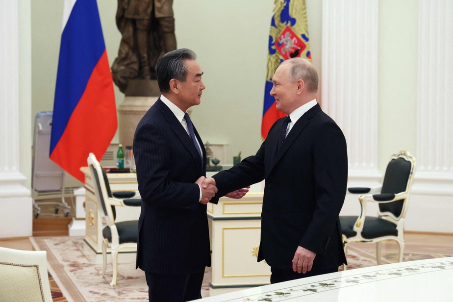 Presidente da Rússia, Vladimir Putin, cumprimenta chanceler chinês, Wang Yi, em Moscou