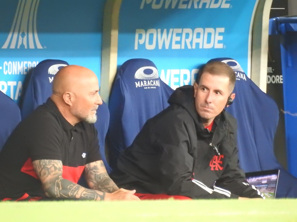 Sampaoli sentado ao lado do auxiliar Diogo Meschine. Isso aconteceu antes de o Flamengo entrar em campo e foi cena rara &mdash; Foto: Fred Gomes