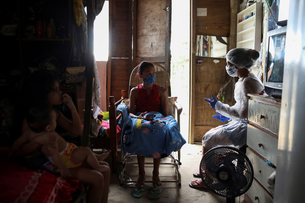 Vanda conversa com uma paciente durante visita a sua casa — Foto: Bruno Kelly/Reuters