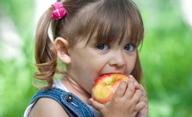 Criança comendo maçã (Foto: Shutterstock)