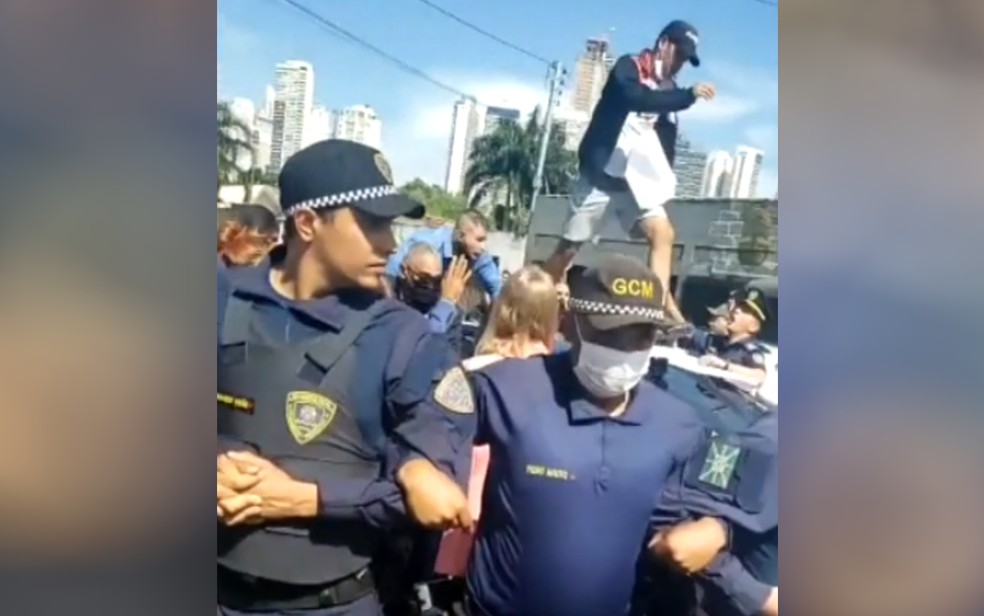 Professores são detidos durante protesto em inauguração de Cmei em Goiânia; homem subiu em carro da prefeitura