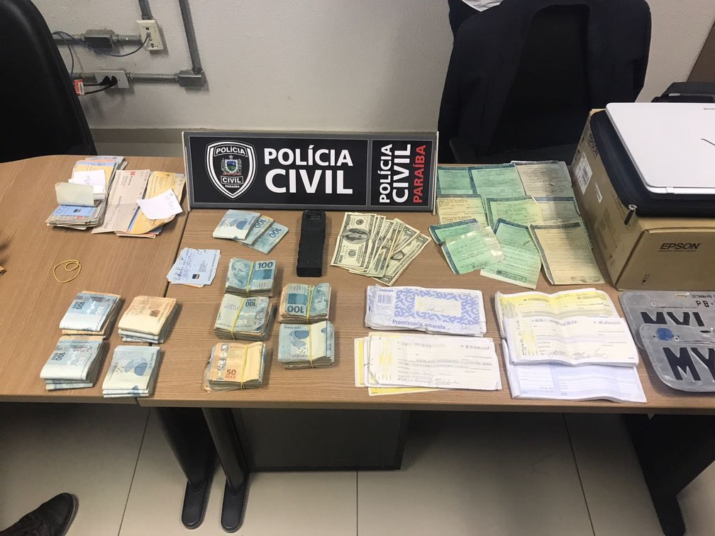 Dinheiros, cheques e placas de carro foram apreendidos em depósito de suspeitos de agiotagem em João Pessoa (Foto: Lucas Sá/DDF)