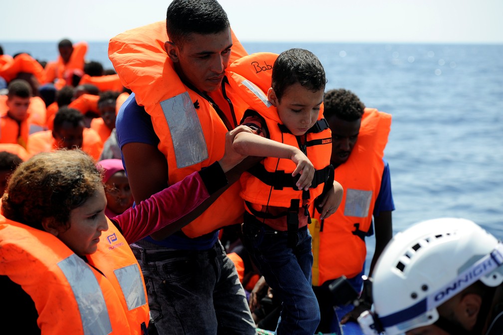 Imigrantes são resgatados por funcionários da ONG SOS Mediterranee nesta sexta-feira (10) no Mar Mediterrâneo (Foto: Guglielmo Mangiapane/Reuters)