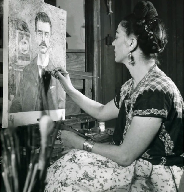 Frida pintando uma de suas incontáveis obras repletas de simbolismo e elementos oníricos (Foto: Museo Frida Kahlo / Reprodução)