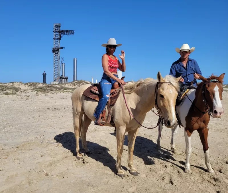 Gene Gore com sua mulher e cavalos na praia de Boca Chica, à frente da plataforma de lançamento da SpaceX (Foto: ANALÍA LLORENTE via BBC News)