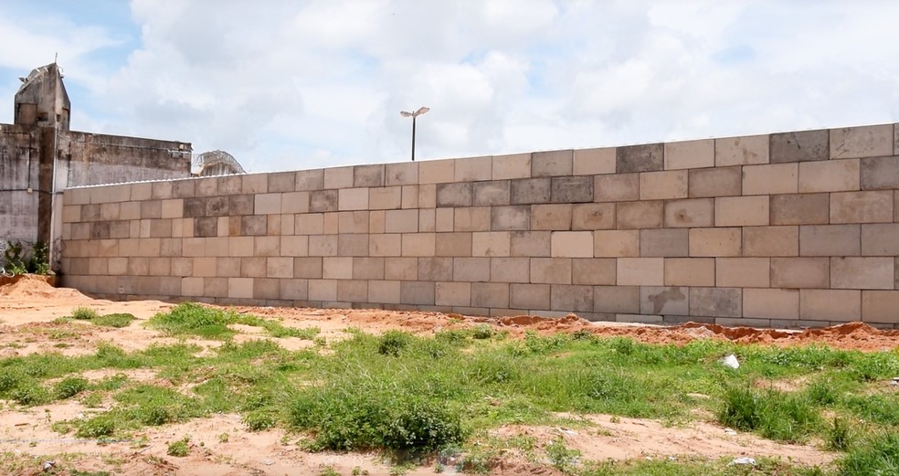 Muro erguido com blocos de concreto tem quase 100 metros de extensão (Foto: Thyago Macedo/G1)