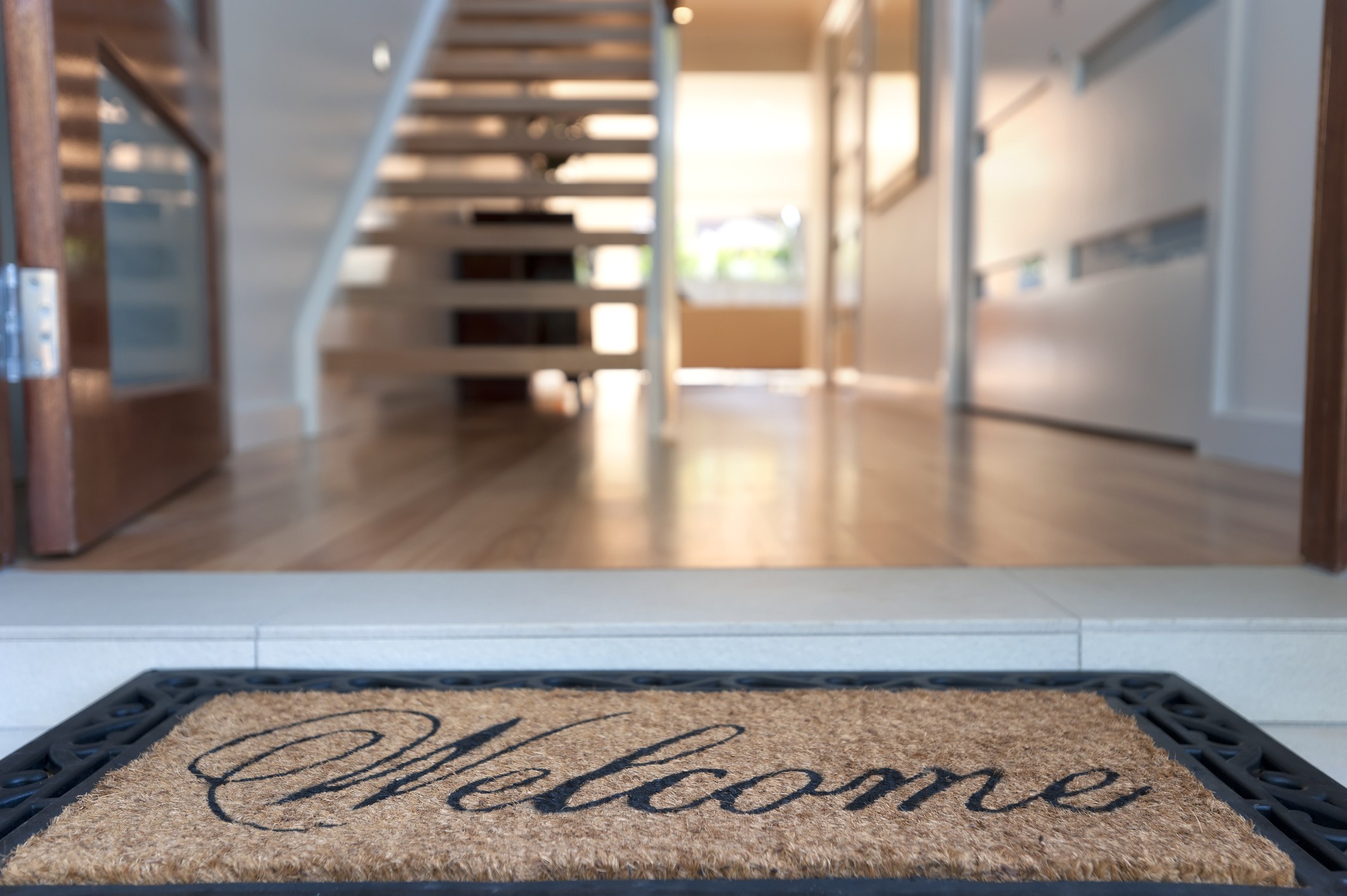 Close up of a welcome mat in front of an inviting house. Focus on foreground (Foto: Getty Images)