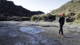 Homem caminha ao lado de poças de água congeladas no Pico das Agulhas Negras, em Itatiaia — Foto: Domingos Peixoto / Agência O Globo