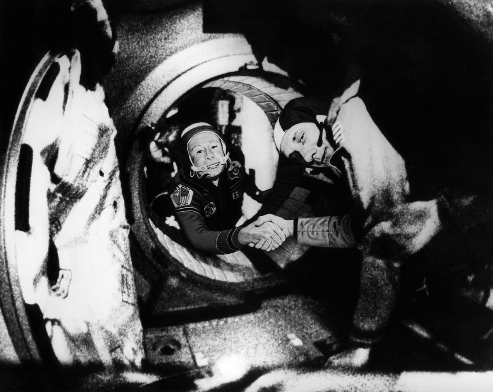 O comandante da tripulação soviética da Soyuz, Alexei Leonov (esquerda) e o comandante da tripulação americana da Apollo, Thomas Stafford (esquerda), apertam as mãos após as manobras de atracação da Apollo-Soyuz, em 17 de julho de 1975 — Foto: HO / NASA / AFP
