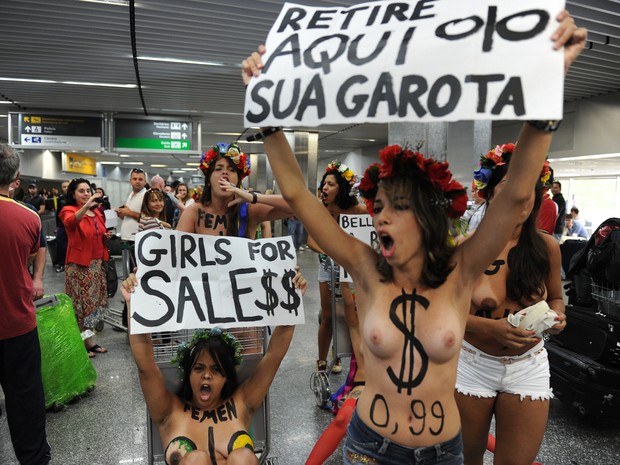 Ativistas do Femen protestam contra turismo sexual no aeroporto do Galeão, no Rio de Janeiro, nesta sexta-feira (8) (Foto: AFP PHOTO/VANDERLEI ALMEIDA)