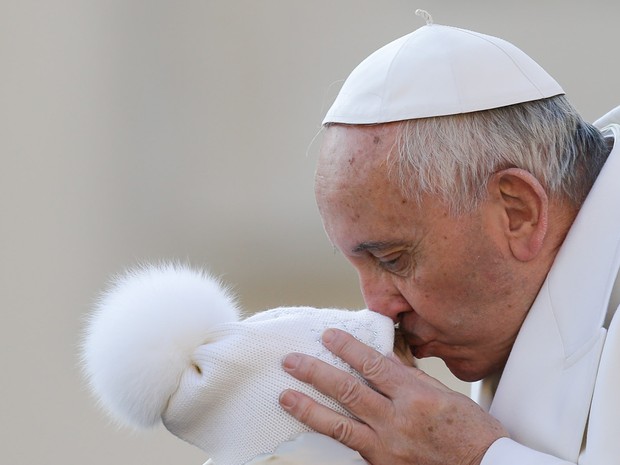 O papa Francisco beija uma criança durante sua chegada para a audiência geral semanal no Vaticano (Foto:  Gregorio Borg/AP)
