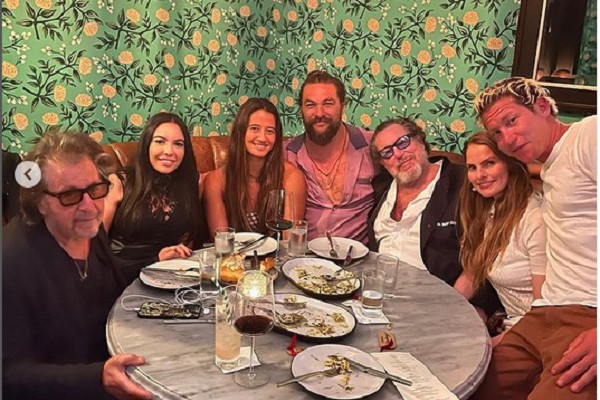 O ator Al Pacino sentado ao lado da produtora Noor Alfallah em jantar com o ator Jason Momoa e amigos (Foto: Instagram)
