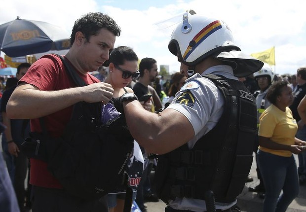 Policiais revistam bolsas e mochilas de manifestantes na Esplanada dos Ministérios em Brasília (Foto: José Cruz/Agência Brasil)