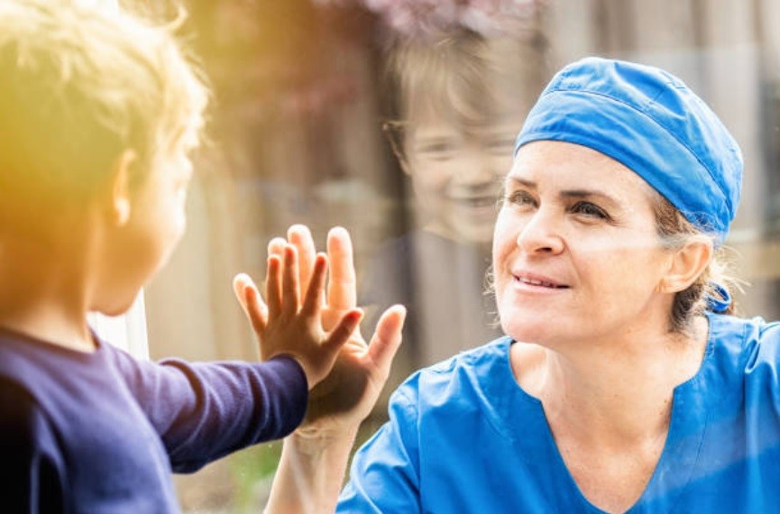 Enfermeira se comunicando com filho através do vidro (Foto: Getty Images)
