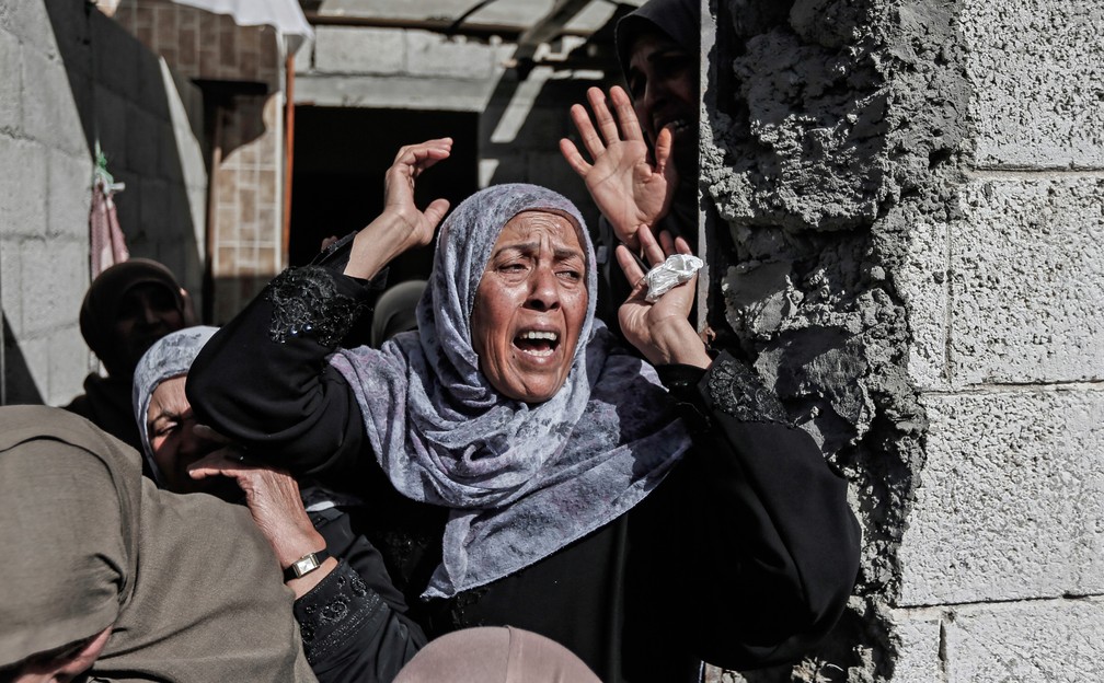 Parentes do palestino Ahmed Abu Jabal, que morreu de ferimentos causados ​​por tiros israelenses em confrontos após manifestações, são vistos durante seu funeral na Cidade de Gaza  — Foto: Mahmud Hams/AFP
